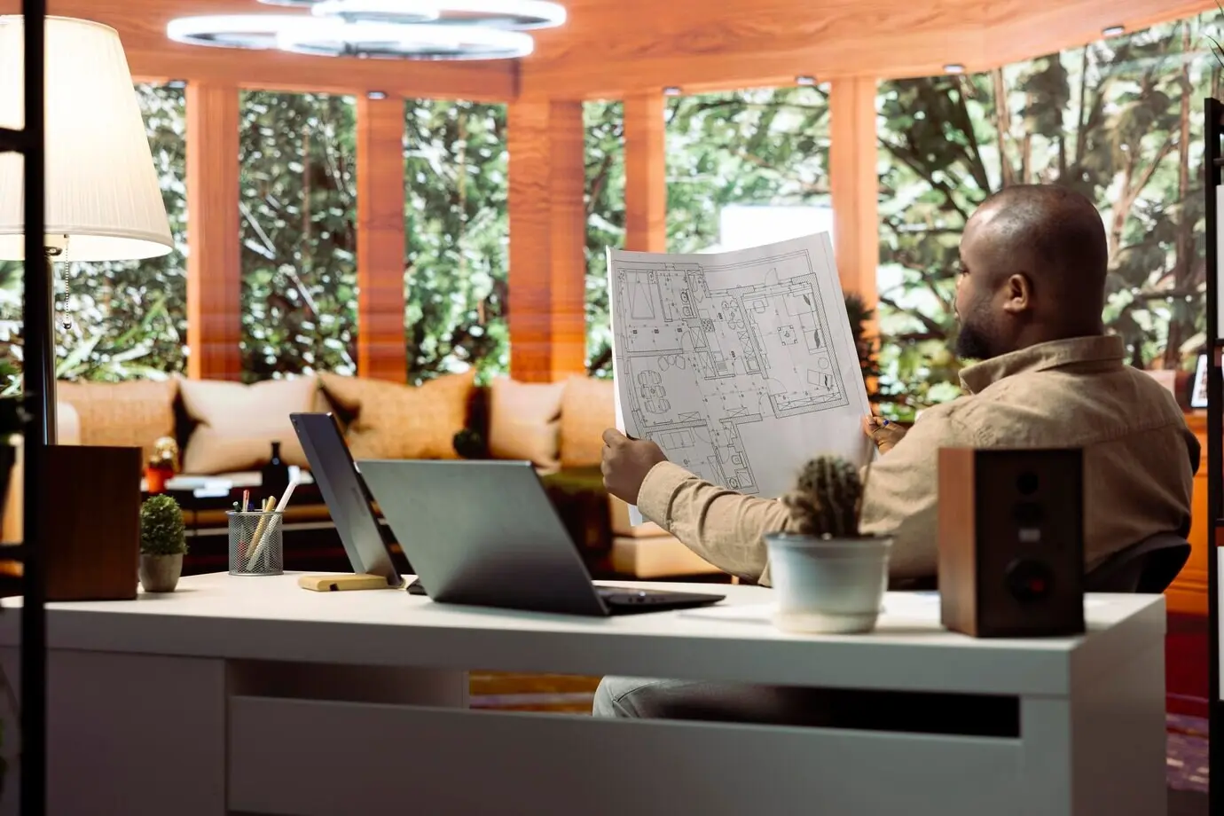 Предприниматель составляет архитектурные чертежи и планирует переезд офиса.