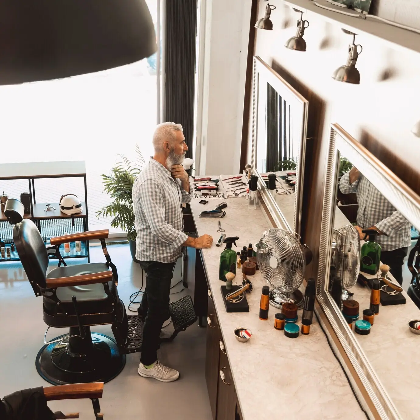 Клиент стоит перед зеркалом в барбершопе.